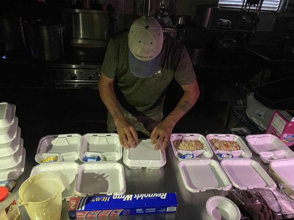 man packages meals in the dark